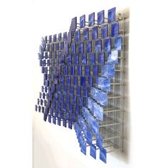 a sculpture made out of blue tiles on a white wall