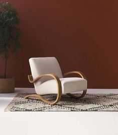 a chair sitting on top of a rug next to a potted plant