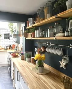 a kitchen with shelves filled with pots and pans on top of the countertop