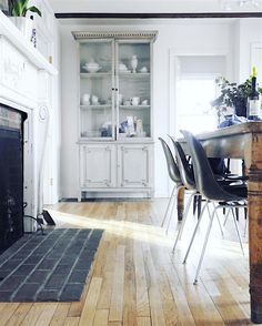 a living room with a fire place sitting next to a dining room table and chairs