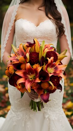 a bride holding a bouquet of orange and red flowers on her wedding day in the fall