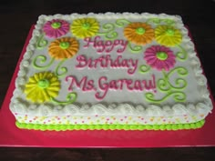 a birthday cake decorated with flowers and the words happy birthday ms garau on it