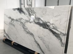 a large marble slab with white and black veining on it's sides in a warehouse