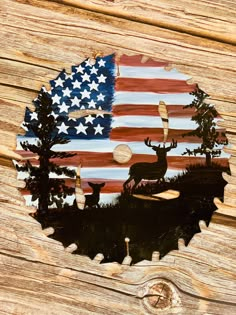 an american flag and deer on a wood background with the silhouette of trees in the center