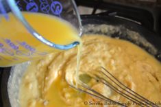 someone is pouring orange juice into a bowl