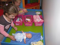 two young children playing with toys in a play room