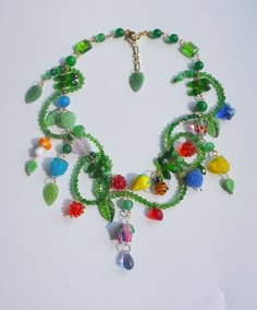 a multi - colored beaded necklace is displayed on a white surface