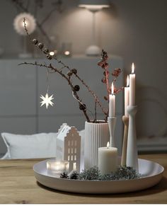 a white plate topped with candles on top of a table next to a candle holder