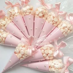 pink and white candy cones are arranged in a pyramid shape with bows on the top