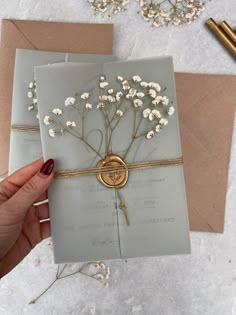 a person holding a card with flowers on it and some cards in front of them