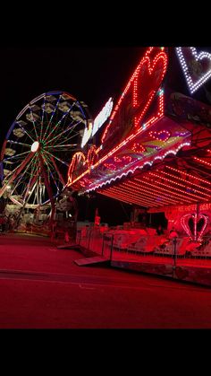 an amusement park at night with ferris wheel and lights