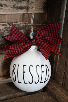 a white ornament with a red and black ribbon on it