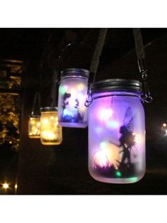 three mason jars with fairy lights hanging from them