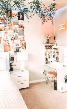 a bedroom with white furniture and lots of pictures on the wall above it, along with a plant hanging over the bed