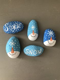 four painted rocks with snow written on them