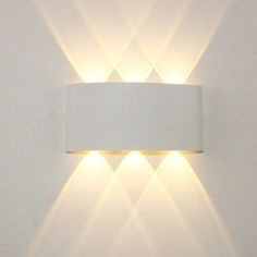 a white wall mounted light with three lights on it's sides and one is turned on