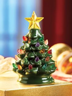 a small christmas tree sitting on top of a gold box