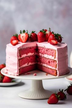 a strawberry layer cake with one slice cut out and topped with strawberries on a plate