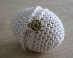 a close up of a knitted object with a button on the front and side