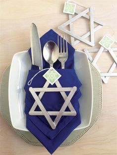 a table setting with silverware and napkins on it, including a star of david