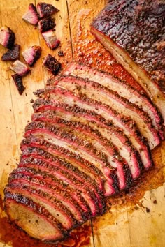 sliced up meat sitting on top of a wooden cutting board