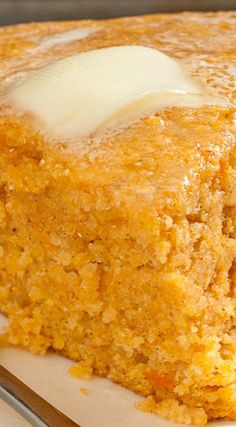 a piece of cornbread on a plate with a fork and knife next to it