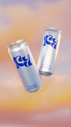 two cans of soda are flying through the air in front of a pink and blue sky