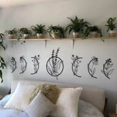 a bed with pillows and plants on the wall