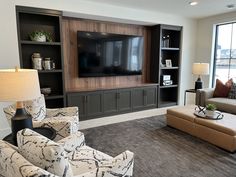 a living room filled with furniture and a flat screen tv mounted to the wall above it