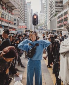 a woman standing in the middle of a crowded street