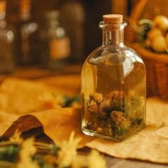 a glass bottle filled with flowers sitting on top of a table