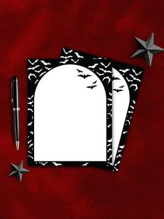 two blank cards with bats and stars next to pen on red background, top view