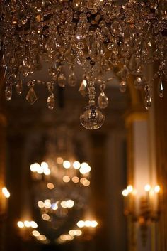 a chandelier hanging from the ceiling in a room with many lights on it