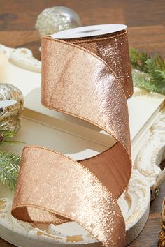 a roll of ribbon sitting on top of a table next to christmas decorations and candles