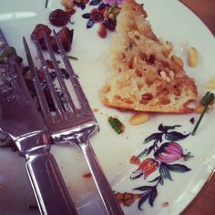 a piece of pizza sitting on top of a white plate next to a fork and knife