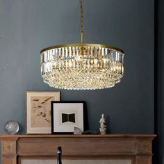 a chandelier hanging over a fireplace in a living room with blue walls and furniture