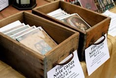 two wooden boxes filled with cards on top of a table