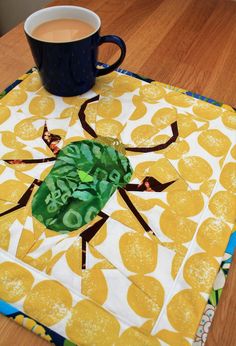 a cup of coffee sitting on top of a table next to a yellow and white cloth