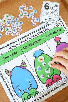 a child's hand is playing with the number one and two worksheet