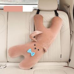 a stuffed animal laying on the back seat of a car