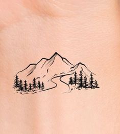 a tattoo on the back of a woman's neck with mountains and pine trees