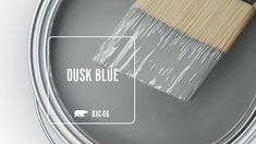 a paint can with a brush in it and the words dusk blue above it