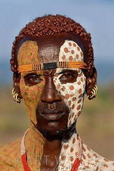 an african man with painted face and headdress