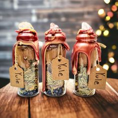 three jars filled with spices sitting on top of a wooden table