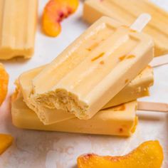 three popsicles with orange slices on them and one is cut in half to look like peaches