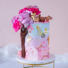 a pink and blue cake with flowers on top