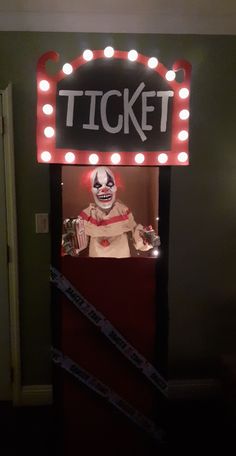 a lighted ticket booth with a creepy clown in it