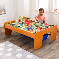 a little boy playing with his toy train set