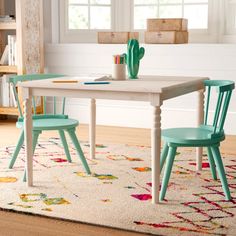 two children's chairs and a table in a room with rugs on the floor