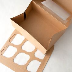 an open cardboard box with cut out circles on the outside and inside, sitting on a white surface